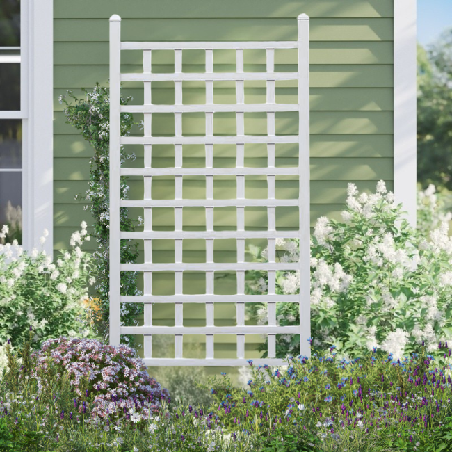 Vinyl garden trellis with square lattice design, used as a support for flowering vines, set against a green background, creating a charming garden display.